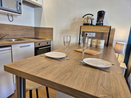 - une cuisine avec une table en bois et des verres à vin dans l'établissement Les Loges du Beffroi - L'azur, à Arras