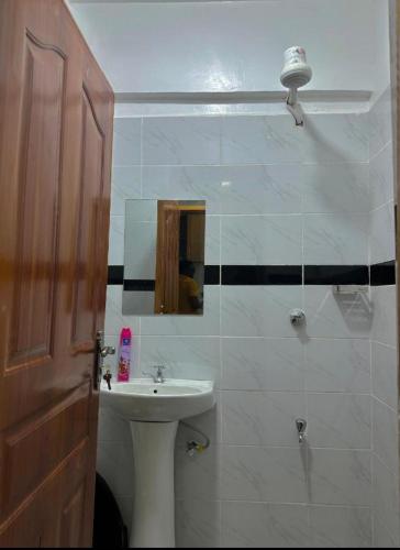 a bathroom with a sink and a mirror at Koki Airbnbs Kamakis in Ruiru