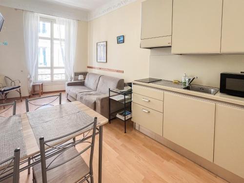 une cuisine et un salon avec un canapé et une table dans l'établissement Nice 66 4 Pers AC WiFi, à Nice