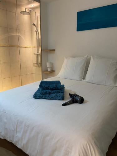 une lampe de poche noire posée sur un lit blanc dans l'établissement Petit Port, à Cogolin