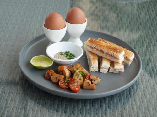 a plate of food with eggs and toast and vegetables at Naki Suites @ Silvertown in Phnom Penh