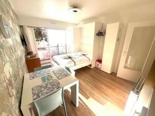 Cette petite chambre comprend une table et un lit. dans l'établissement Les Pieds dans leau avec parking, à Les Sables-dʼOlonne