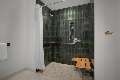 佩索罗伯斯Bellasera Hotel & Suites Paso Robles, Tapestry by Hilton的带淋浴和长凳的浴室