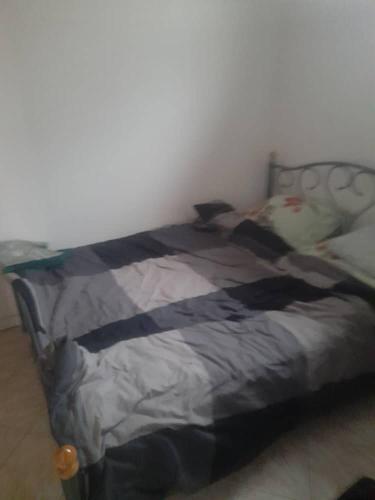 un lit avec une couverture noire et grise dans une chambre dans l'établissement Appartement calme & proche Paris, à Bois-Colombes