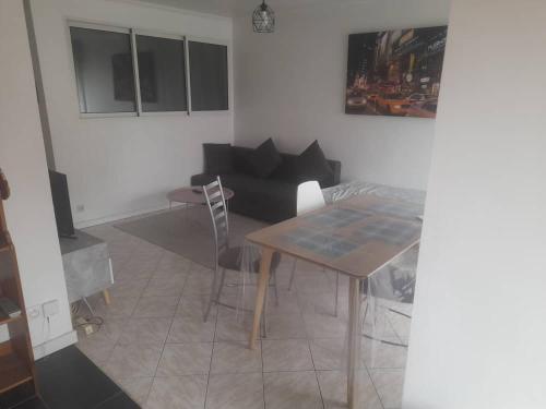 un salon avec une table et un canapé dans l'établissement Appartement calme & proche Paris, à Bois-Colombes