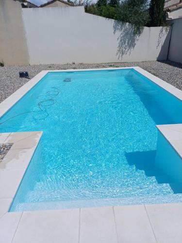 une piscine avec de l'eau bleue dans une cour dans l'établissement Maison de vacances familiale en Provence, à Monteux