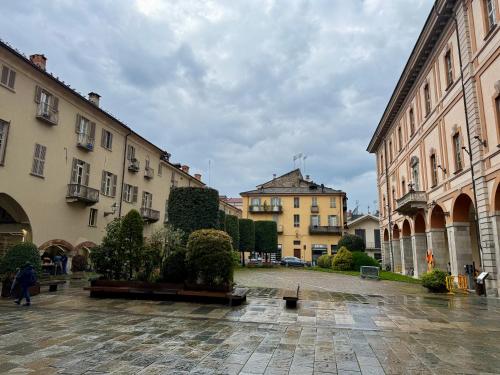a group of buildings in a city with a courtyard at La Loggia dei Mercanti in Cuneo