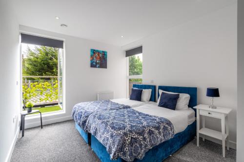 a bedroom with a bed and two windows at free parking,Top location, Shops in Edgware