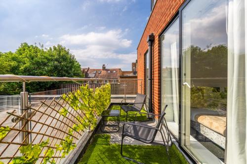 a balcony with two chairs and glass doors at free parking,Top location, Shops in Edgware