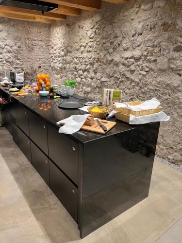a kitchen with a black counter top in a stone wall at Boutiquehotel Rattenberg in Rattenberg