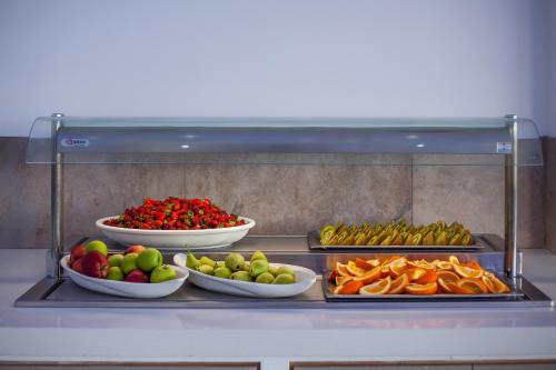 a bunch of fruits and vegetables in bowls on a shelf at Cyprotel Florida in Ayia Napa