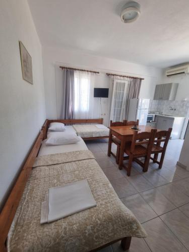 a living room with two beds and a table at Sun Ray Sivota 7 in Syvota