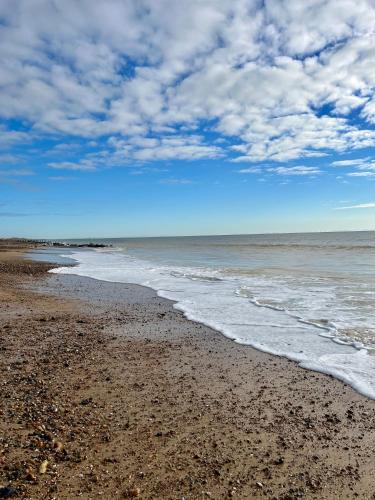 a beach with the ocean on a cloudy day at The Beach Retreat - A Bijou Seaside Maisonette in Rustington