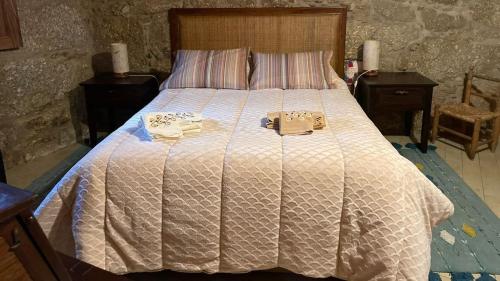 a bedroom with a large bed with two shoes on it at Casa dos Moinhos de Aveia in Alverca