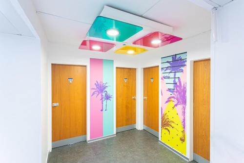 a hallway with colorful doors and a rainbow ceiling at Karibea La Valmenière Hôtel in Fort-de-France