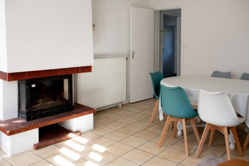 - un salon avec une cheminée, une table et des chaises dans l'établissement La Montpensier - maison dans le centre ville d'Eu, à Eu