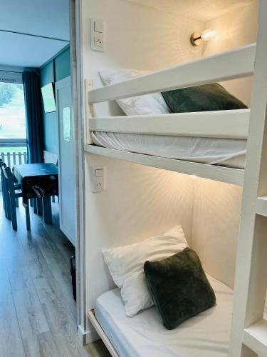 une chambre avec des lits superposés avec une table dans l'établissement Le Vert Montagne Studio lumineux plein sud, à Saint-Étienne-en-Dévoluy