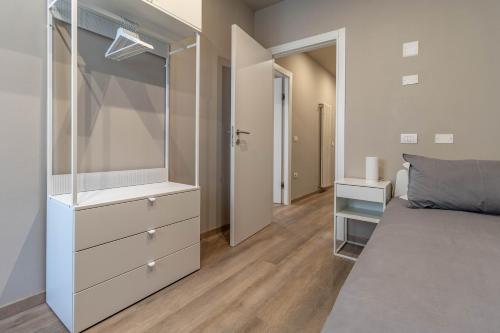 a bedroom with a bed with a dresser and a mirror at IdealHome Suite in Padova