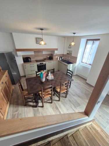 une cuisine et une salle à manger avec une table et des chaises dans l'établissement Maison de village rénovée, à Luz-Saint-Sauveur