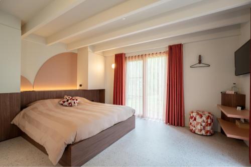 a bedroom with a large bed with red curtains at De Rietreiger in Blankenberge