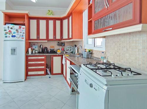 a kitchen with a stove and a white refrigerator at enjoy in Cesme