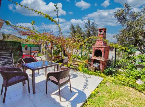 a patio with a table and chairs and a fireplace at enjoy in Cesme