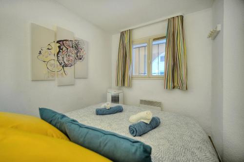 - une chambre avec 2 oreillers bleus sur un lit dans l'établissement Palm Beach 128 - Appartement dans résidence clim - wifi proche mer, à Cannes