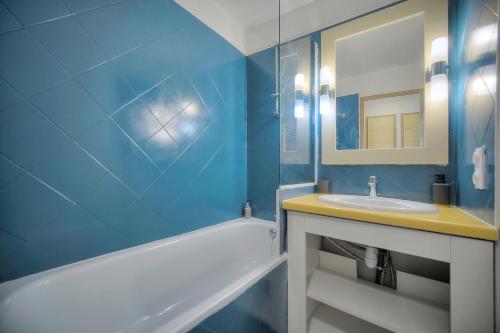 une salle de bain bleue avec un lavabo et un miroir dans l'établissement Palm Beach 128 - Appartement dans résidence clim - wifi proche mer, à Cannes