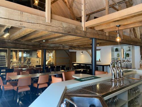 a restaurant with wooden ceilings and tables and chairs at Landgoed De Hoogmolen in Oudsbergen 