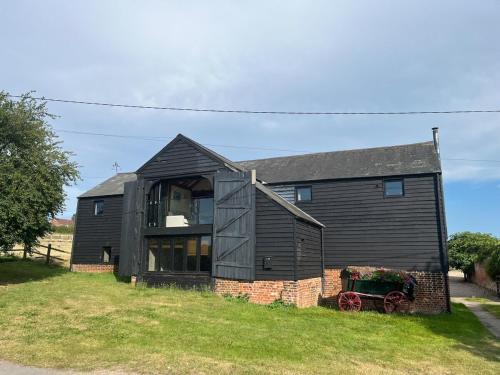 a black house with a window on the side of it at Wheatsheaf Barn in Manningtree