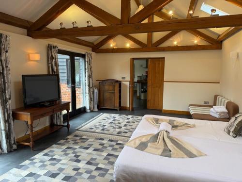 a living room with a bed and a tv at Wheatsheaf Barn in Manningtree