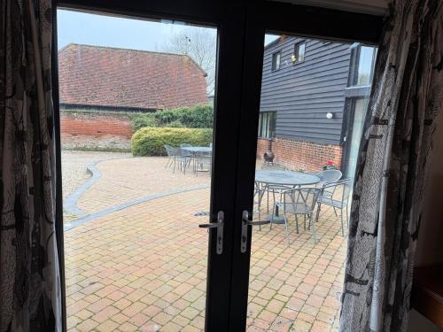 an open door to a patio with a table and chairs at Wheatsheaf Barn in Manningtree
