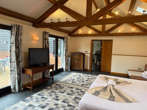 a living room with a bed and a tv at Wheatsheaf Barn in Manningtree