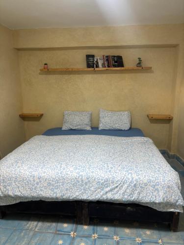 a bedroom with a bed with two pillows on it at Jara Cimrmann surf house in Imsouane