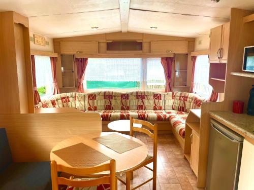 a living room with a couch and a table at Charmant Bungalow avec piscine et emplacement voiture in Yvoir