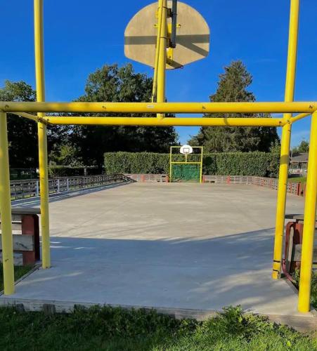 a yellow basketball hoop on a basketball court at Charmant Bungalow avec piscine et emplacement voiture in Yvoir