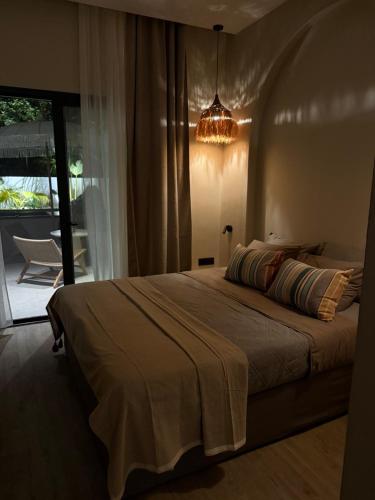 a bedroom with a large bed and a chandelier at erasmia luxury suite in Georgioupolis