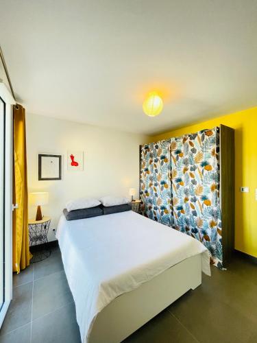 - une chambre avec un grand lit et une tête de lit fleurie dans l'établissement Antibes Old Center Charming Brand New Apartment, à Antibes