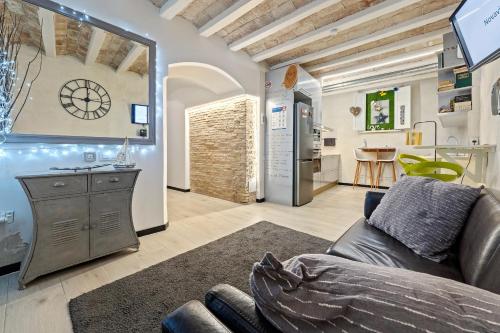Una sala de estar con un sofá y una cocina. en Hauzify I Novavila Centre Rooms, en Vilanova i la Geltrú