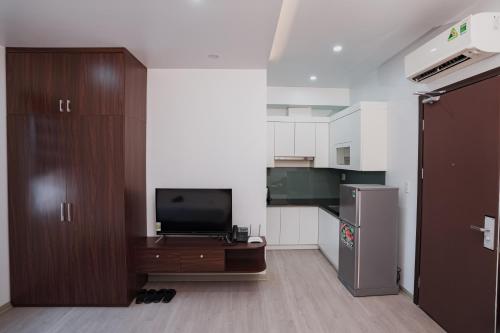 a living room with a tv and a kitchen at The Eastern Hotel & Apartment in Hai Phong