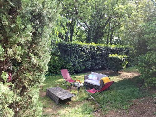 a garden with two chairs and a couch and a table at Gite OLIVIRA in Vesseaux