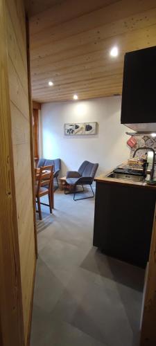 Cette chambre comprend une cuisine avec des chaises et une table. dans l'établissement Les Flocons, aux Gets