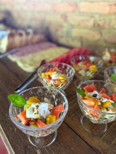 Paraíso Capitólio "A Pousada da Dona Perpetua" في كابيتوليو: أربعة أطباق من الخضار على طاولة خشبية