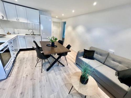 a living room with a couch and a table at Leilighet med tre soverom Feel like home in Tromsø