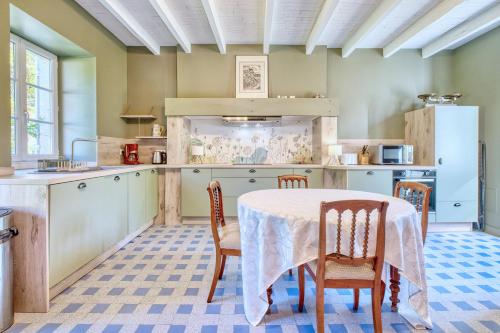 une cuisine avec une table et des chaises dans une pièce dans l'établissement Les Orchidées, à Razac-sur-lʼIsle