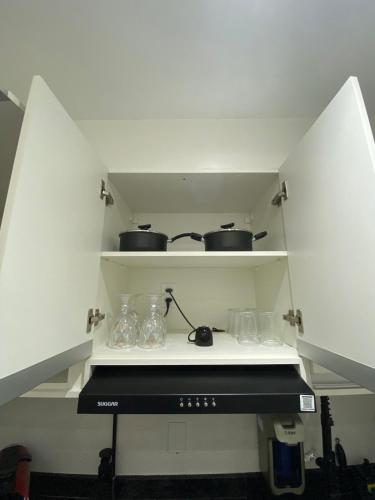 a kitchen with two pots and pans on a stove at Ap Smart Bosque in Campinas