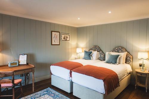 a bedroom with a bed and a table and a desk at Bel and The Dragon-Odiham in Odiham