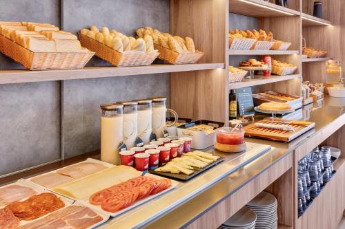 a buffet line with bread and pastries and other foods at B&B HOTEL Alicante in Alicante