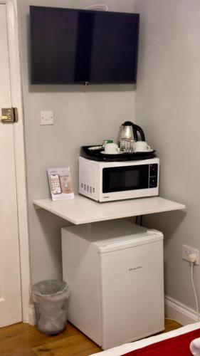 a microwave sitting on a shelf in a room at Classic Hyde Park Hotel in London