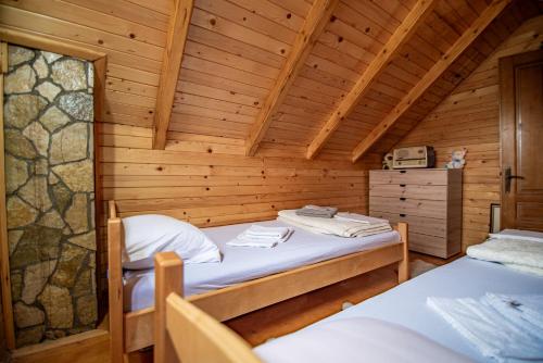 a room with two beds in a wooden cabin at Private Cabin in the Woods in Žabljak